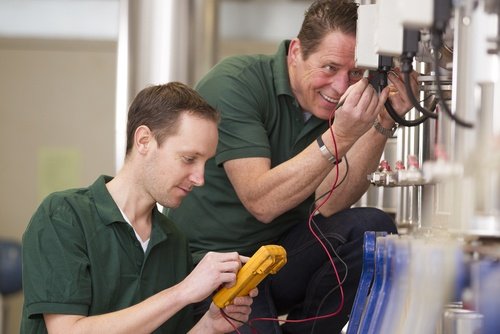 two men maintaining a machine