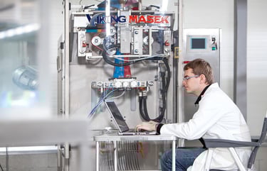 man-typing-on-computer-near-Viking-Masek-vffs-machine.jpg